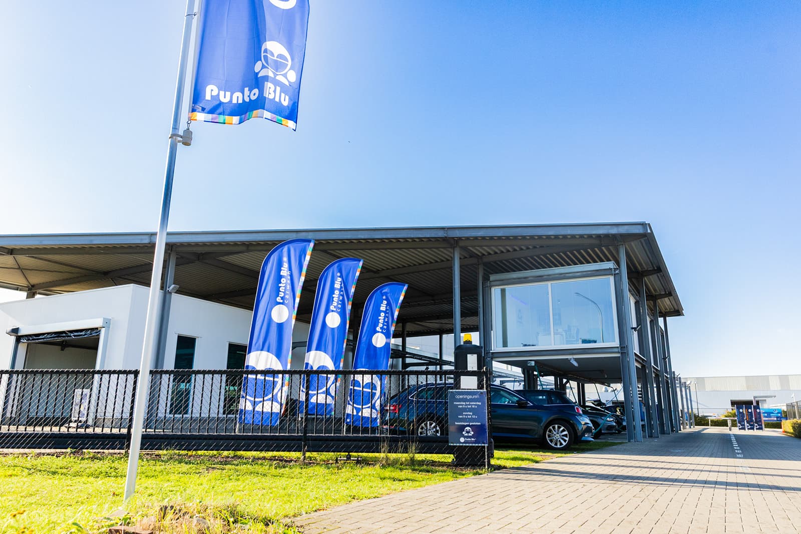 Punto Blu vestiging met vlaggen en carwash overkapping